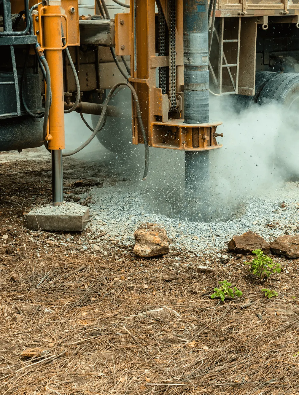 Foreuse de sondage de sol en action, avec poussière et gravats projetés lors d'une étude de pollution